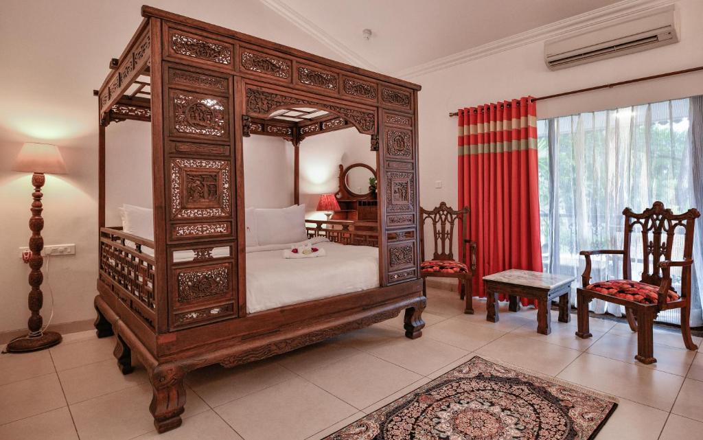 Indian wooden bed at night at Storii By ITC Hotels, Shanti Morada. Goa Best luxury hotels & resorts in North Goa rated 8.5+ for an unforgettable getaway.