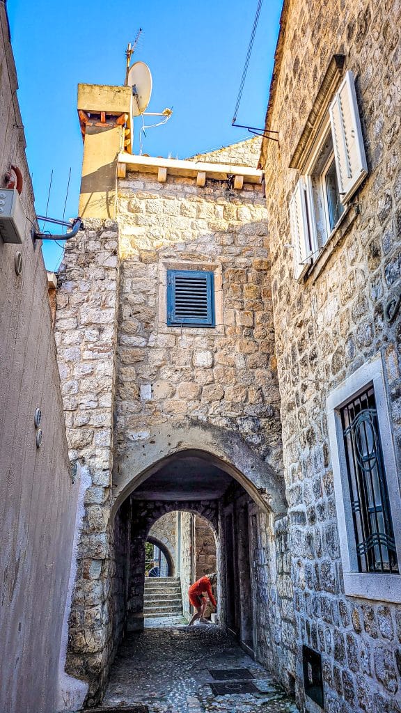 Alley with old small port gate in Dubrovnik. A complete travel guide to Dubrovnik: city walls, fortresses, and day trips