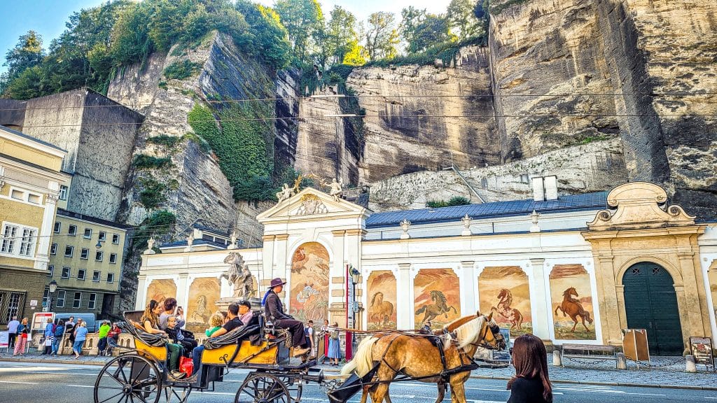Horse and carriage riding through the streets of Salzburg in Austria. Europe solo travel for women: top 20 questions answered