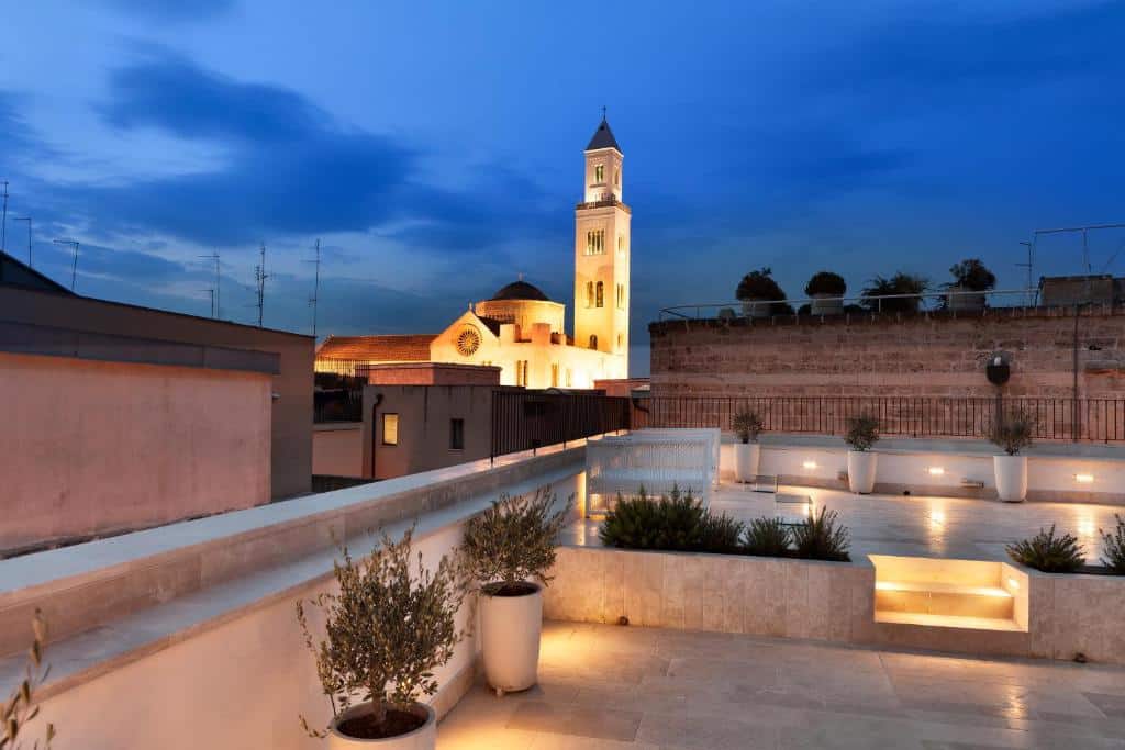 Terrace and clock tower view at night at Palazzo Calò. Bari Travel Guide: Discover Hidden Gems in Puglia’s Capital. In the worlds jungle travel blog.